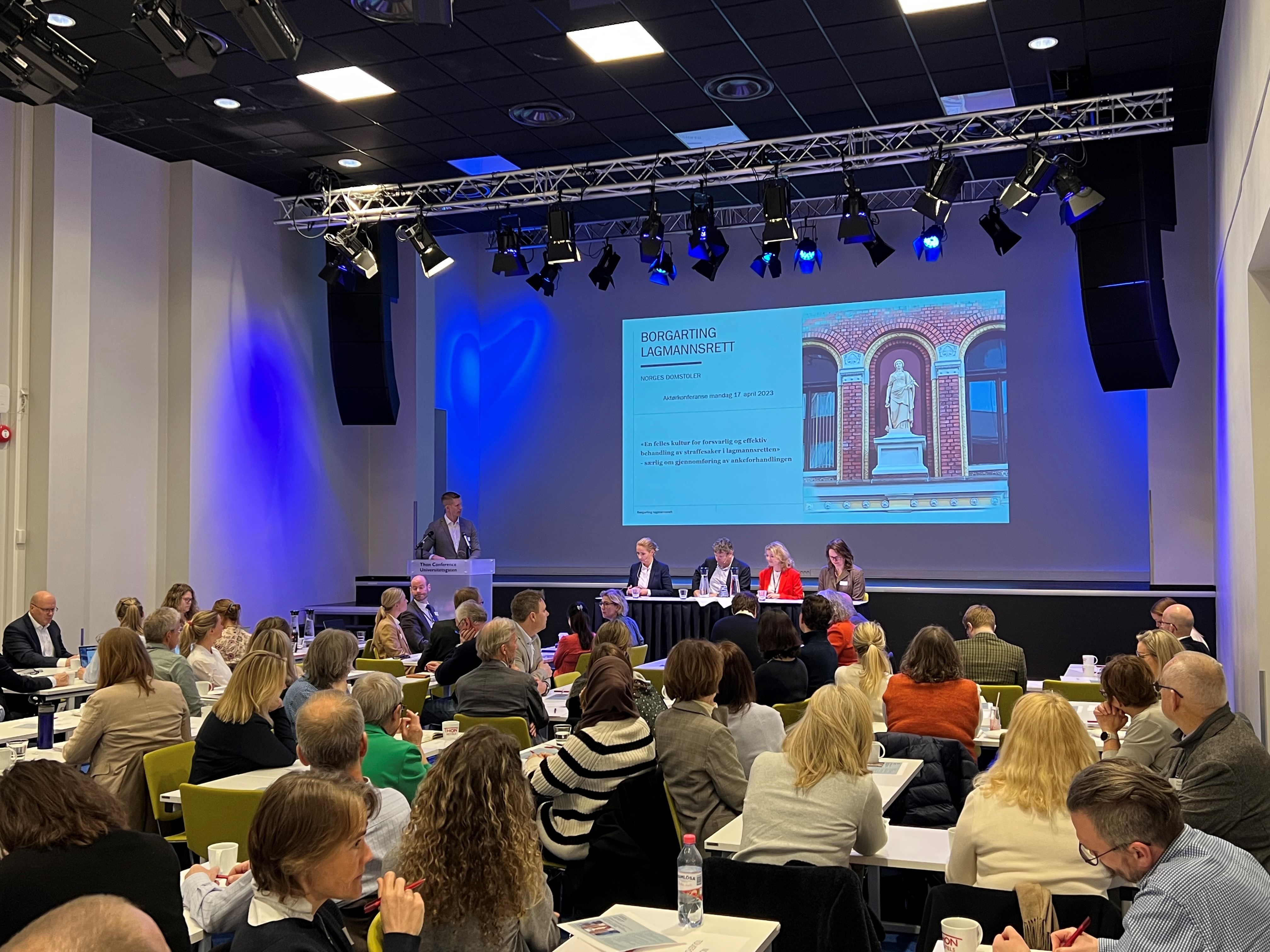 Et bilde fra konferansesalen som viser publikum, en taler og et panel