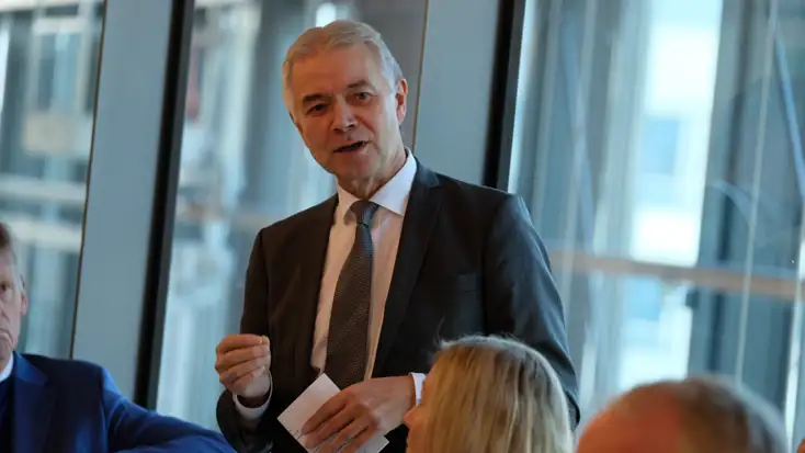 Lagmann Nils Asbjørn Engstad står og snakker til personer ved et bord.