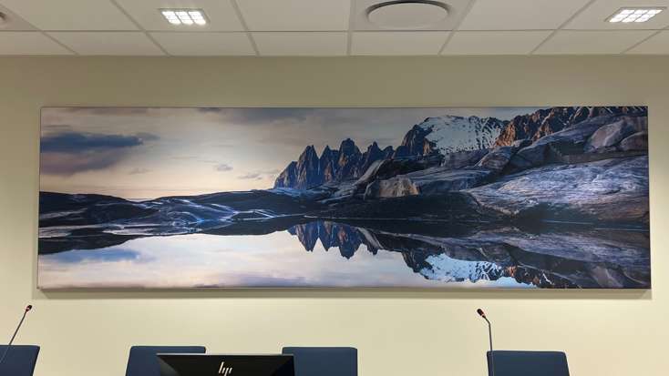 Akustikkplate på vegg inne i en rettssal, utformet med foto av fjellandskap fra Senja.