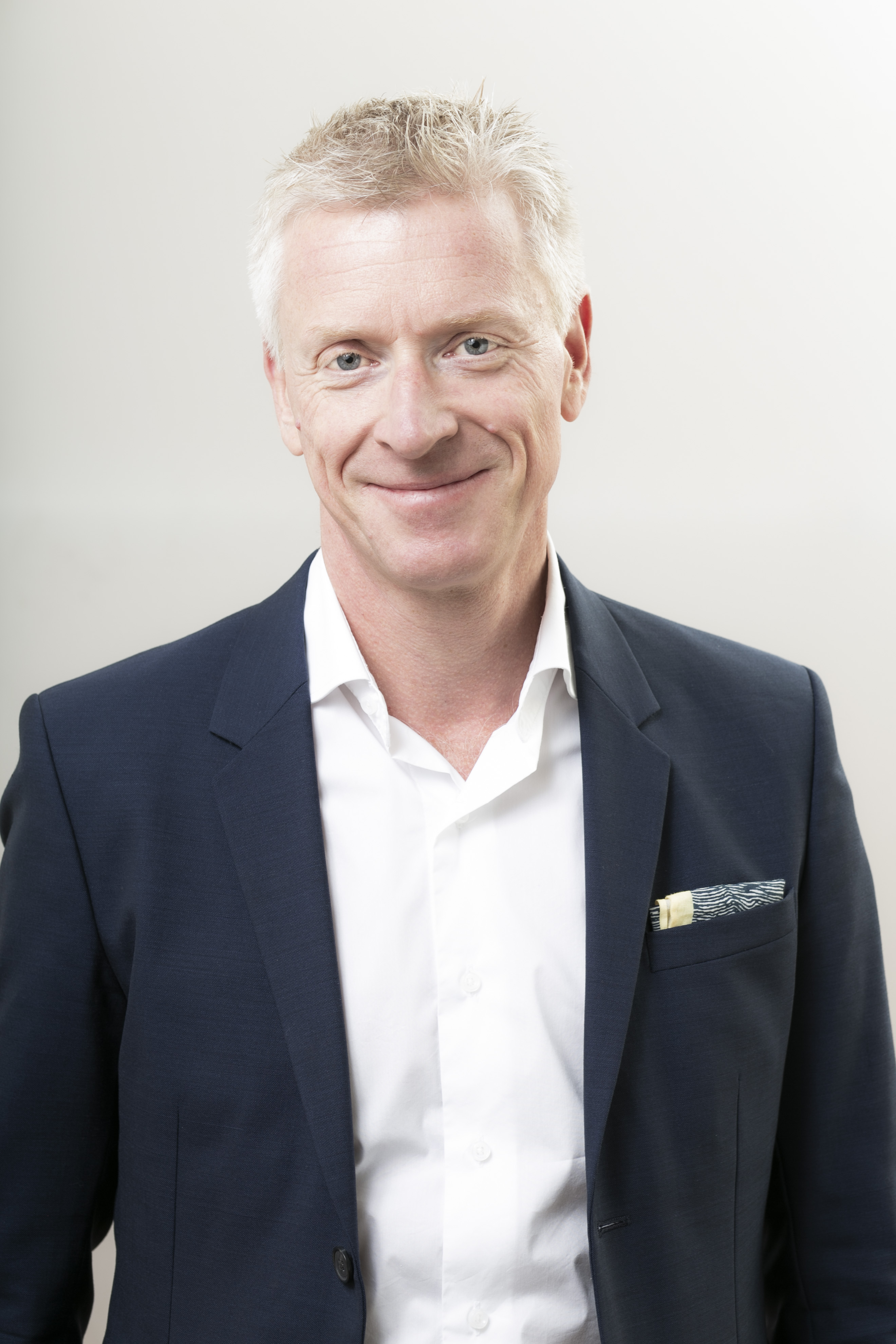 Leif Otto Østerbø smiler til kamera. Han har på seg en mørk dressjakke og en lys skjorte.
