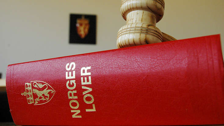 Bilde av Norges lover og en dommerklubbe